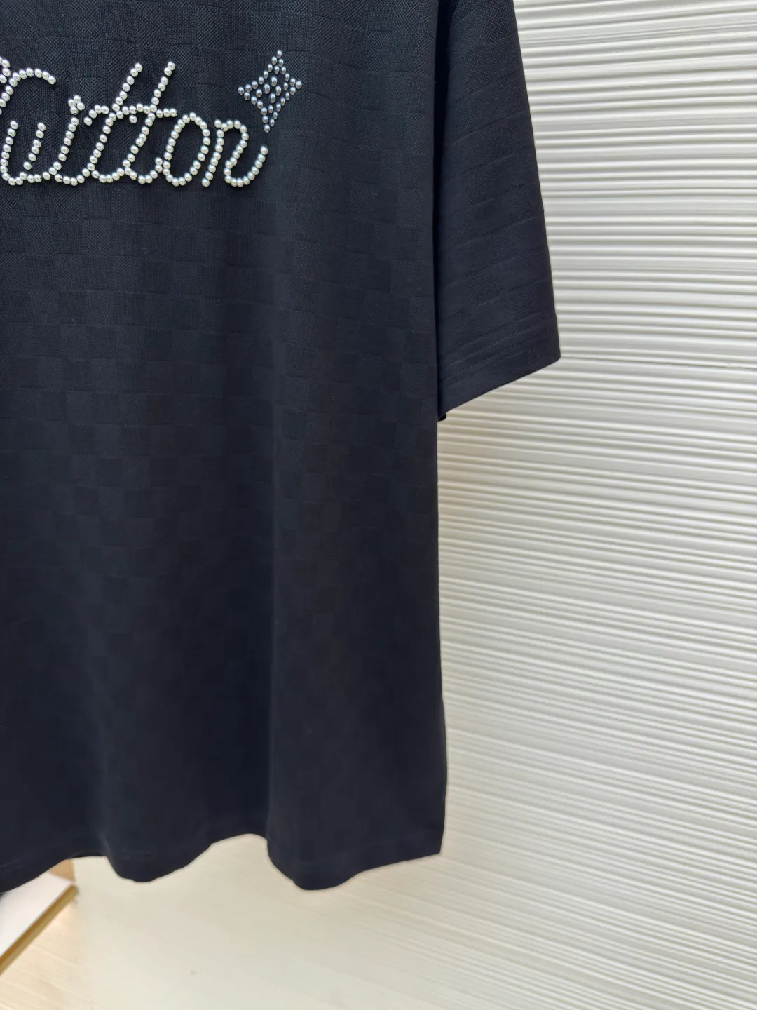 LOUIS VUITTON Hand-signed pearl round neck checkerboard short sleeves ●Authentic product: Purchased and developed by 9574 ●Item No.: 1680354-A55 ●Fabric: Silk full jacquard fabric ●Technology: Beaded embroidery production ●Version: Fitted version ●Weight: about 270 grams ●Size: XS-S-M-L ●Description: Made of 50S double-stranded optical filament, 210g; with 32S double-yarn thread, 300g. The smooth jacquard fabric uses silk threads with better gloss as warp and weft threads, and uses complex jacquard technology to weave delicate and exquisite triangular patterns on the entire fabric. The fabric not only has a beautiful appearance and feel, but also has an overall higher quality feel. The silk jacquard fabric design adds a unique charm to the product through exquisite patterns and textures. The chest presents beaded embroidery and rivet technology combined with patterns. Beaded embroidery is a special decorative method that combines beads and embroidery technology. This decorative method usually uses pearl materials on textiles, which are stitched and embroidered to form various patterns and shapes. Bead embroidery has unique artistic characteristics and expressive power to create colorful, clear-layered and three-dimensional decorative effects. The overall wiring is straight and delicate, the fabric is comfortable and soft, and the color is consistent without color difference. It can be matched with the same style to create a fashionable look and control various occasions. Customized accessories, complete with three standards, same style for men and women!
